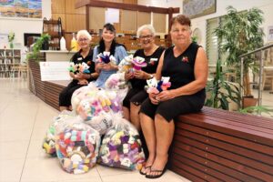four women with bags of hand knitted teddy bears